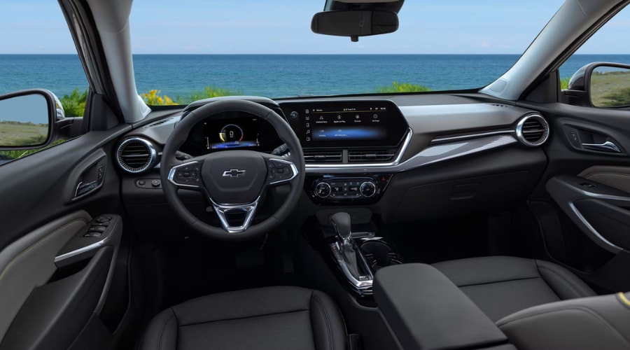 Interior dashboard of a 2026 Chevy Trax featuring an 11-inch touchscreen infotainment display, digital instrument cluster, and tactile climate controls on a coastal South Jersey drive near Marlton, NJ.