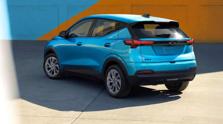 Rear profile of a bright blue 2027 Chevy Bolt showing sleek LED taillights and rear spoiler, part of the new inventory at Elkins Chevrolet near Marlton and Evesham, NJ