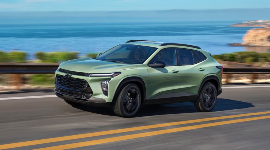 Dynamic front three-quarter driving view of a Cacti Green 2026 Chevy Trax cruising along an open highway, highlighting smooth vehicle handling and active safety tech available at Elkins Chevrolet near Marlton, NJ.