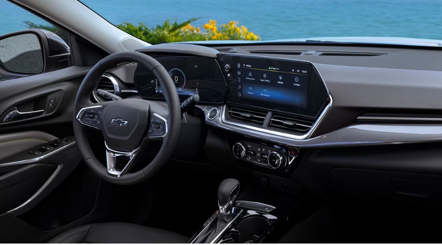 Interior dashboard view of a 2026 Chevy Trax showing the 11-inch central touchscreen infotainment display with wireless Apple CarPlay and Android Auto icons alongside the 8-inch digital Driver Information Center cluster, featured at Elkins Chevrolet in Marlton, NJ for South Jersey drivers.
