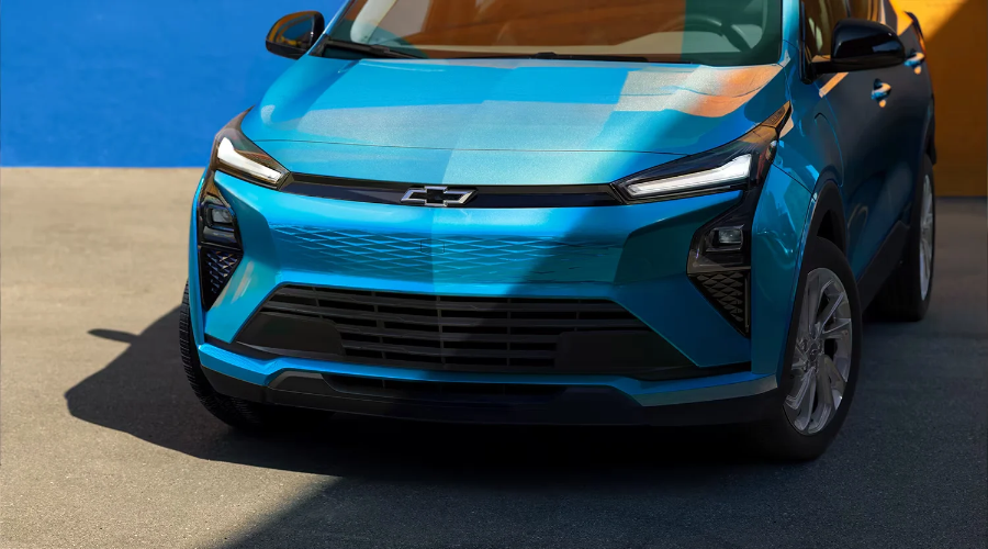 Front fascia detail of a light blue 2027 Chevy Bolt featuring modern LED light bars and textured grille trim, available at Elkins Chevrolet near Marlton and Cherry Hill, NJ