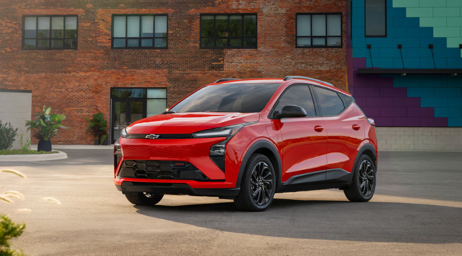 Red 2027 Chevy Bolt RS electric vehicle parked outdoors, available in the large lot inventory at Elkins Chevrolet near Marlton and Evesham, NJ