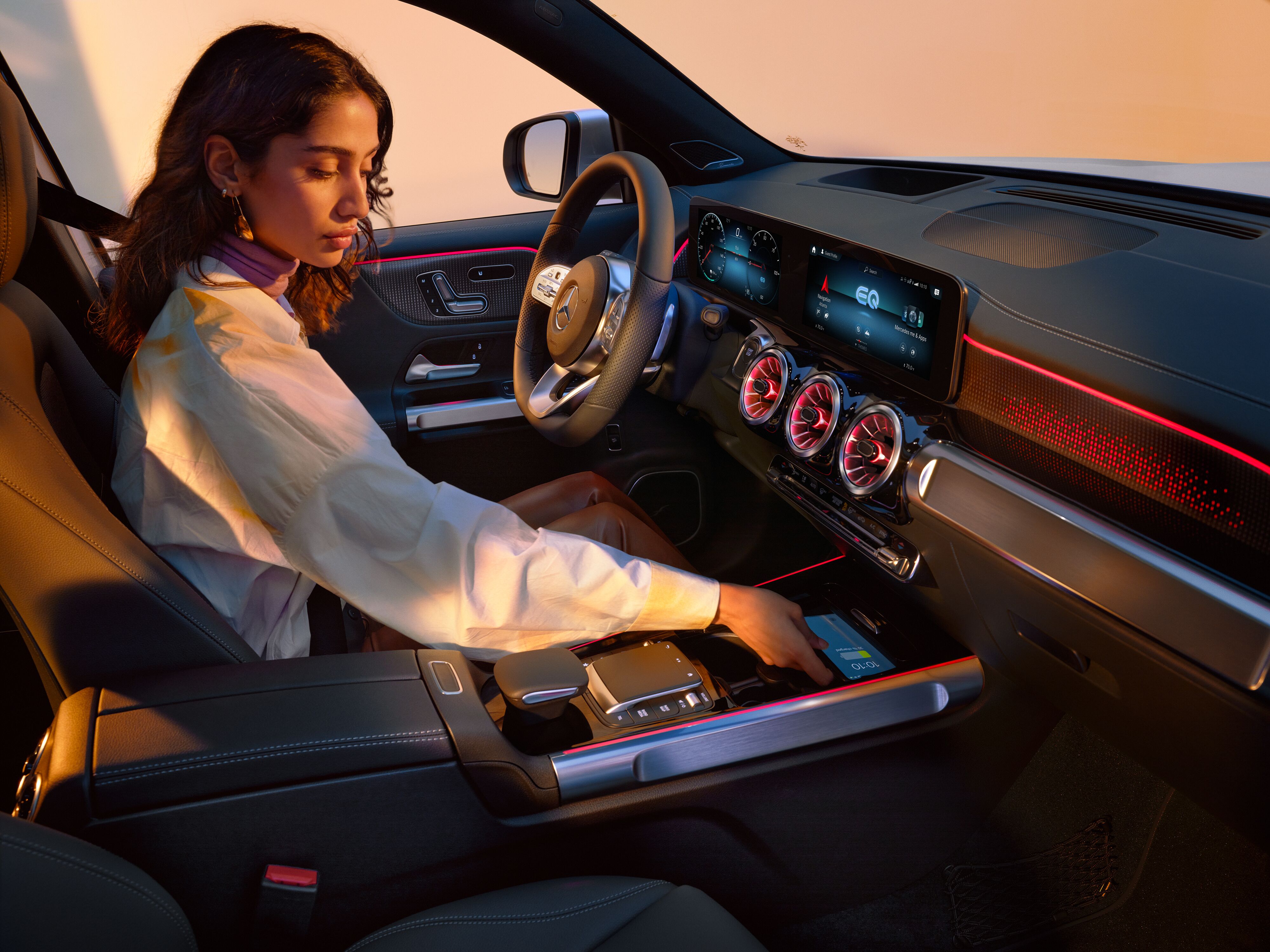 Woman driving a Mercedes-Benz and charging her cell phone in the car