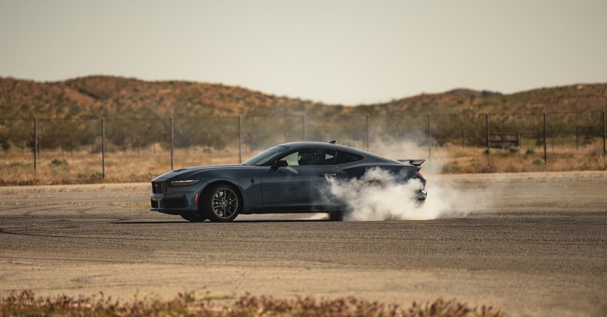 2025 Ford Mustang Sedan drifting on asphalt in the desert