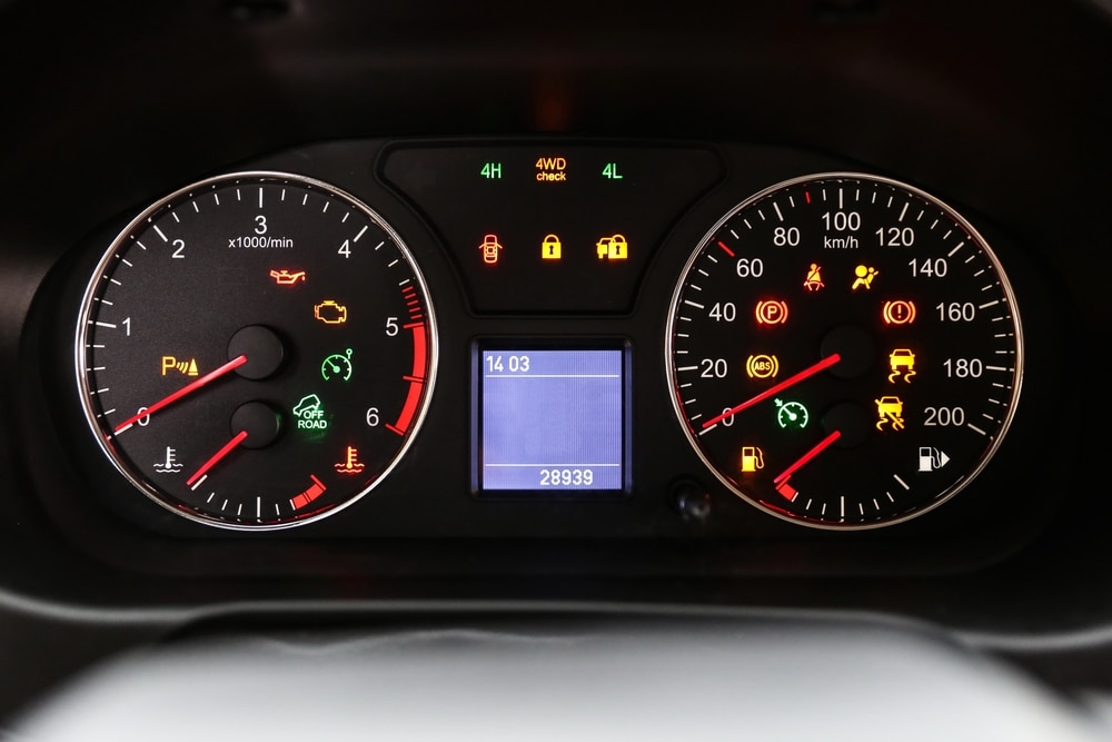 Car%20dashboard%20displaying%20a%20tachometer%20on%20the%20left%20and%20a%20speedometer%20on%20the%20right%2C%20both%20illuminated%20with%20various%20warning%20and%20indicator%20lights%2C%20including%20check%20engine%2C%20ABS%2C%20seatbelt%2C%20and.jpg