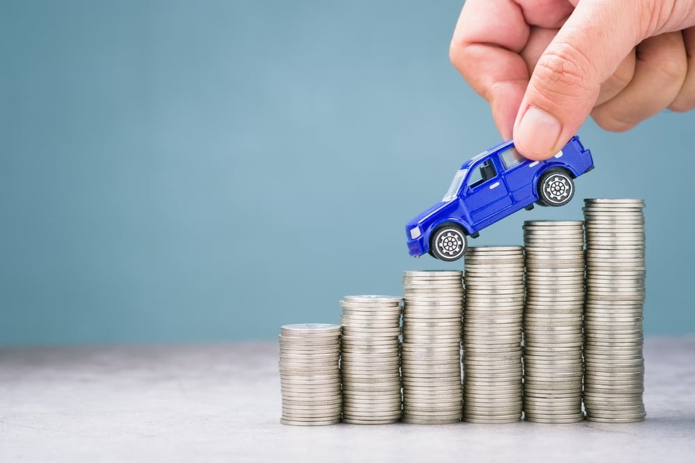 Hand%20placing%20a%20blue%20toy%20truck%20on%20rising%20stacks%20of%20coins%2C%20symbolizing%20increasing%20car%20costs%20or%20growing%20investment%20in%20vehicle%20ownership.jpg