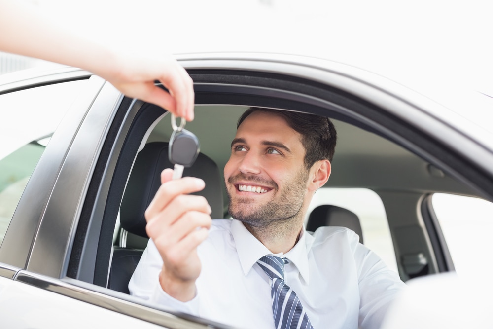 happy man getting the keys for his new car