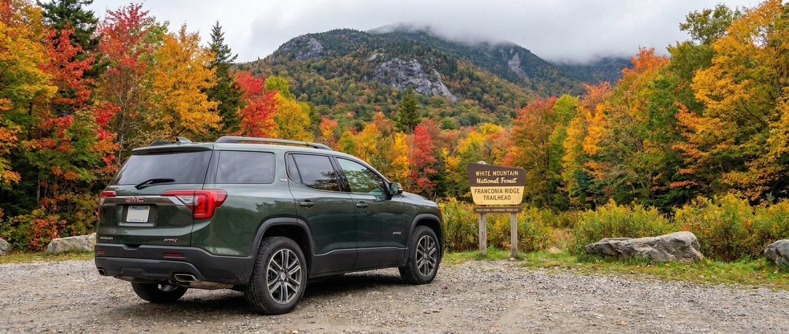 2026 GMC Acadia AT4 at a New Hampshire mountain trailhead surrounded by fall foliage 