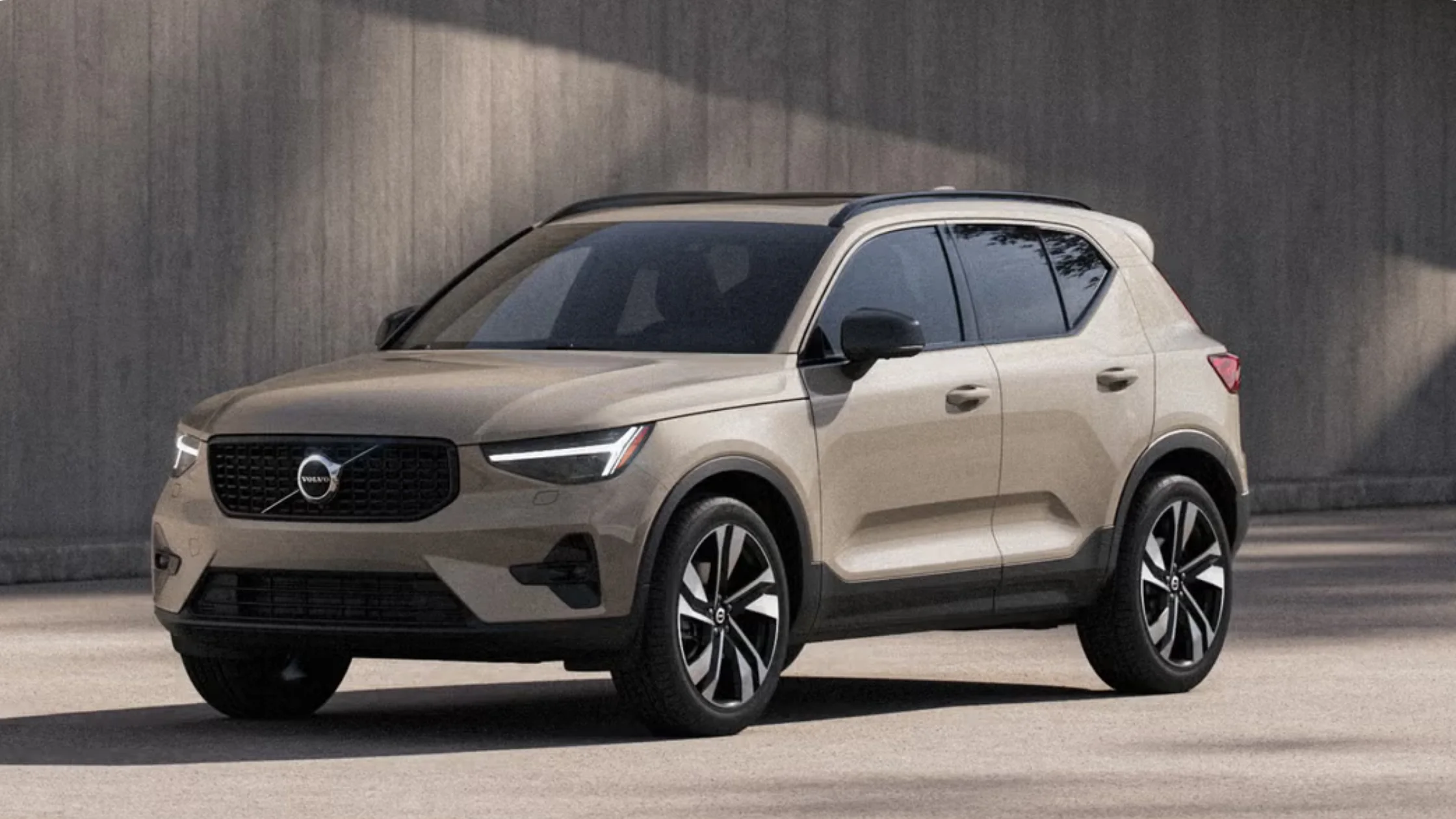 2026 Volvo XC40® compact SUV exterior in beige, front three-quarter angle with LED headlights