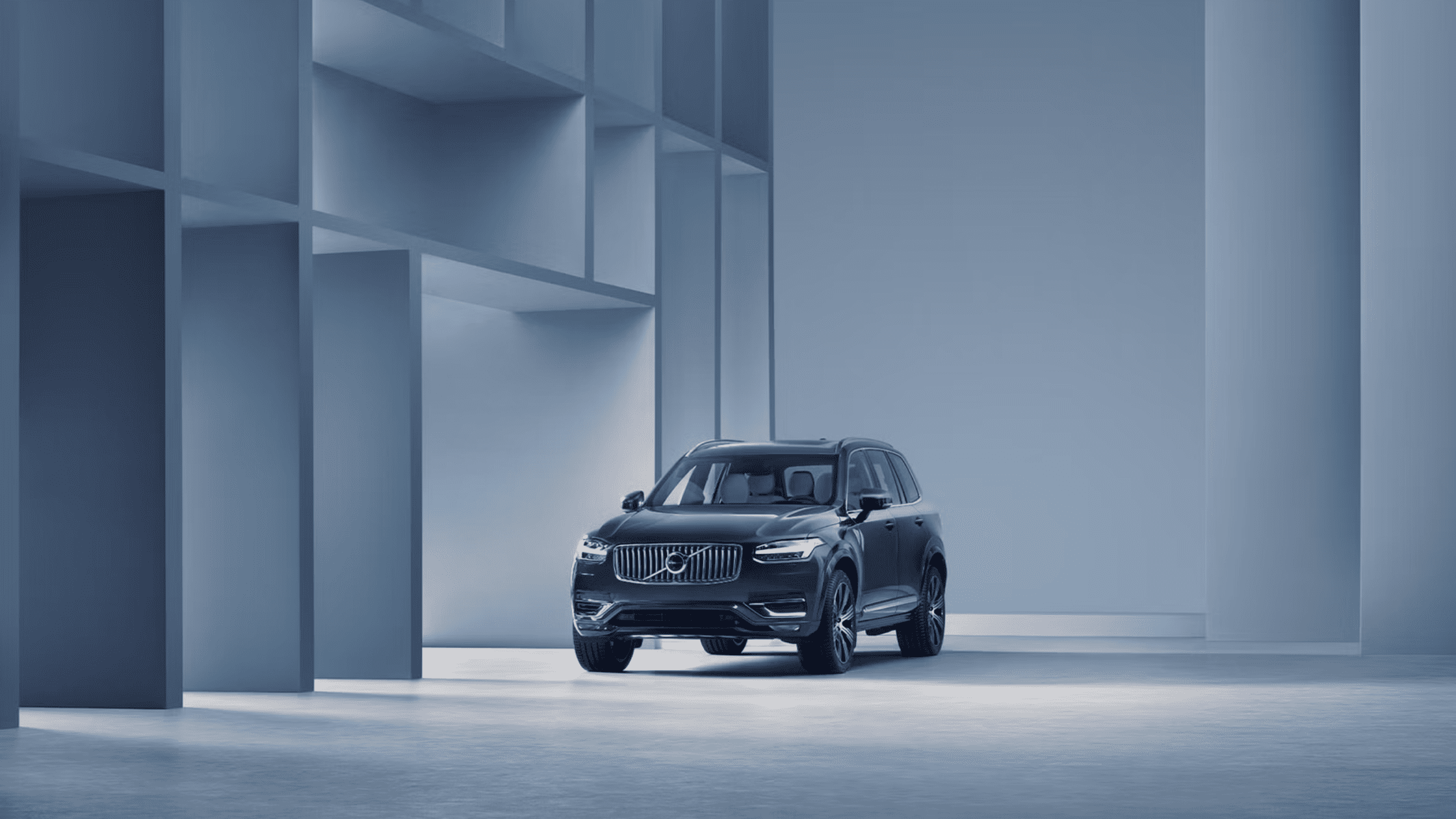 A front view of the 2025 Volvo XC90 in a minimalistic, modern indoor setting with soft lighting