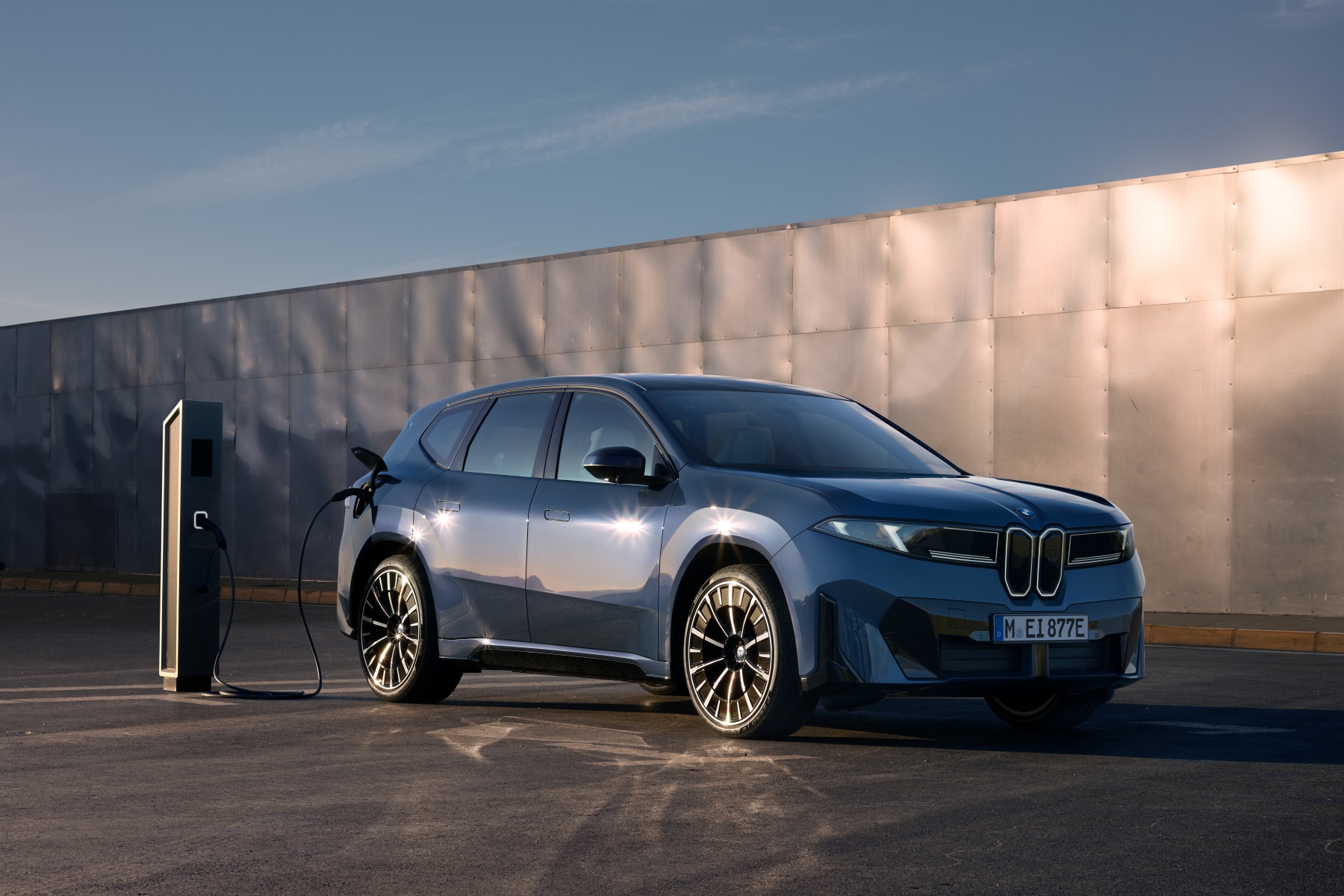 2027 BMW iX3 SUV plugged into a charger