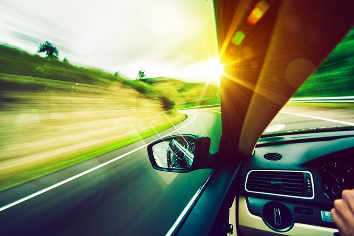 car driving down the road in sunny conditions