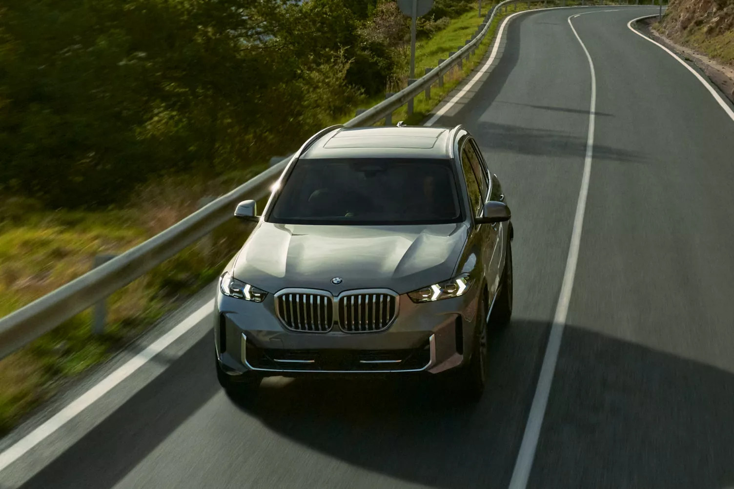 2026 BMW X5 driving down a road