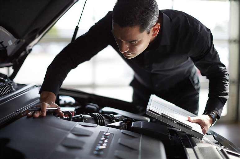 mechanic checking car under the hood