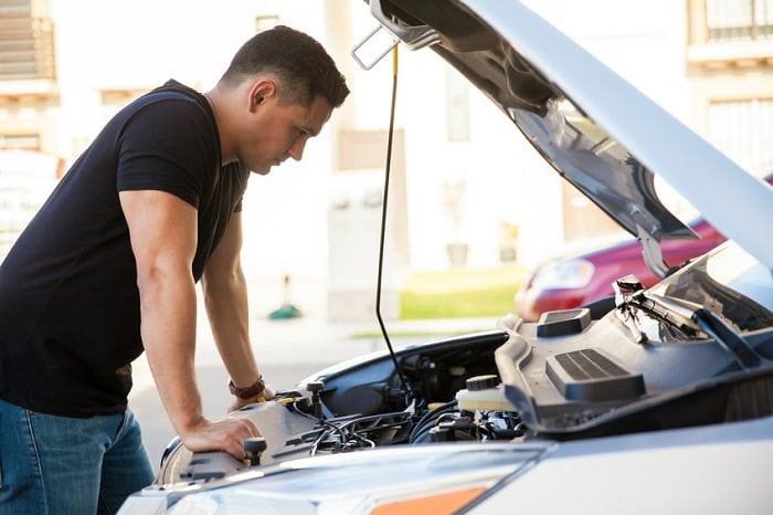 Man looking at the engine of a car