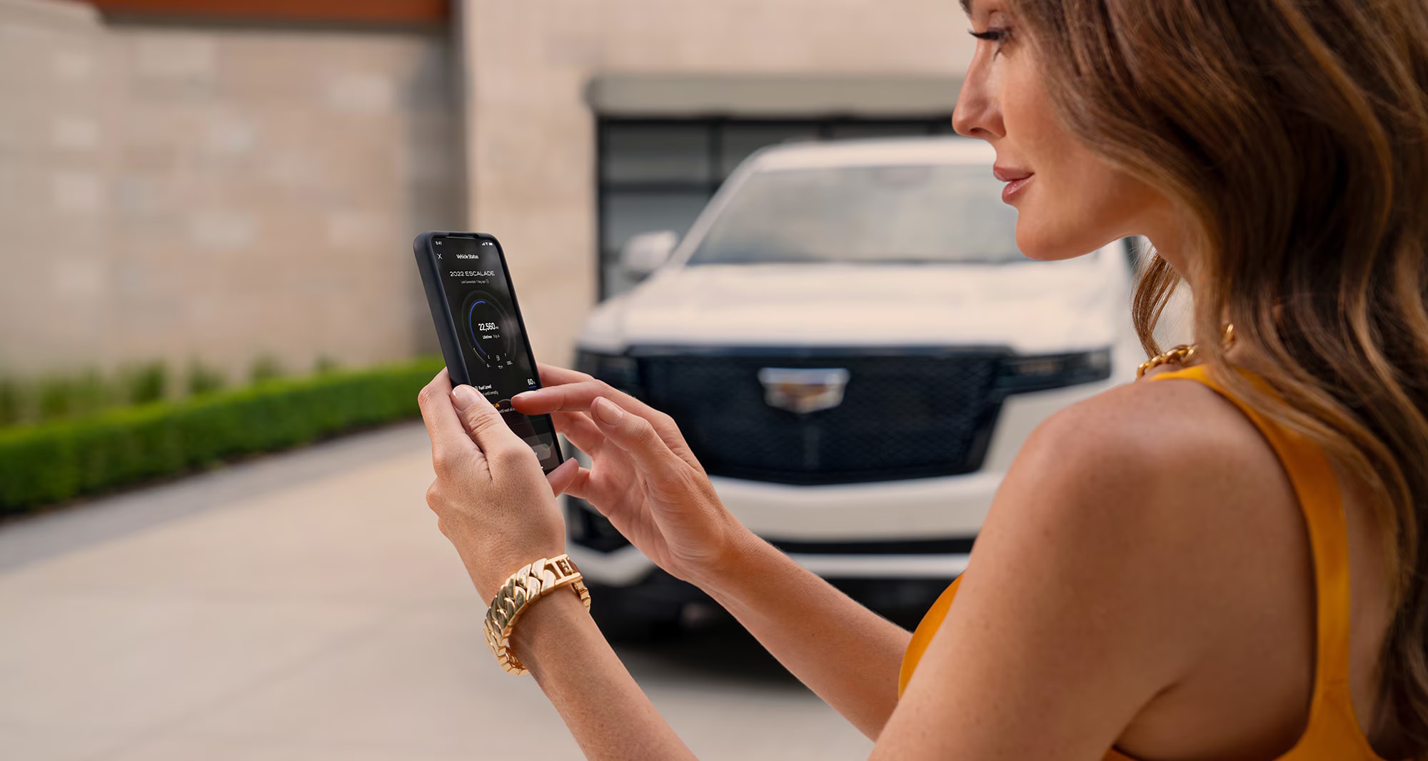 Woman using smartphone for Cadillac Service Pickup and Delivery
