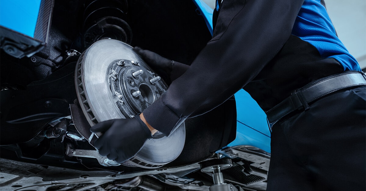 man changing Cadillac brakes