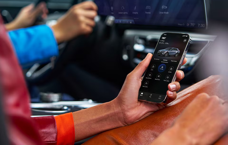 Person holding a smartphone with the MyCadillac App
