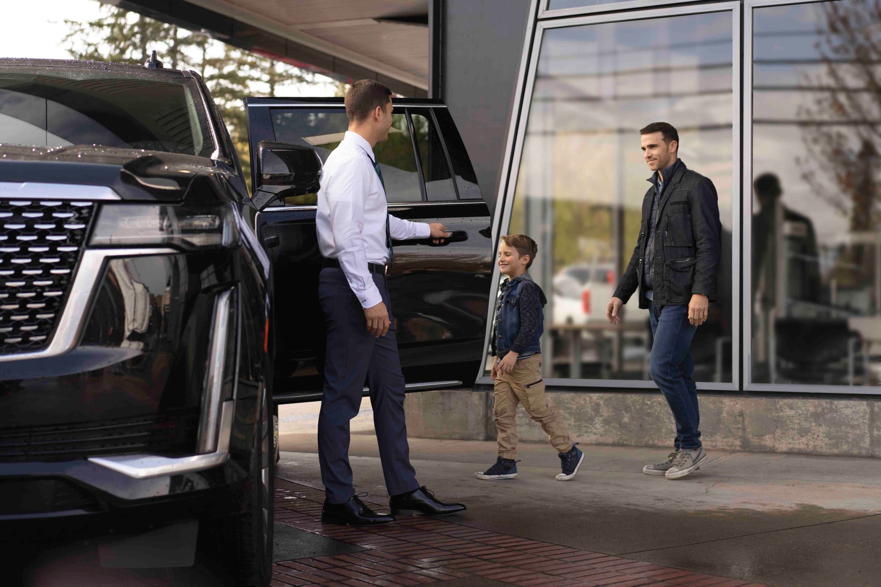 Cadillac dealer with a family and a black Cadillac Escalade