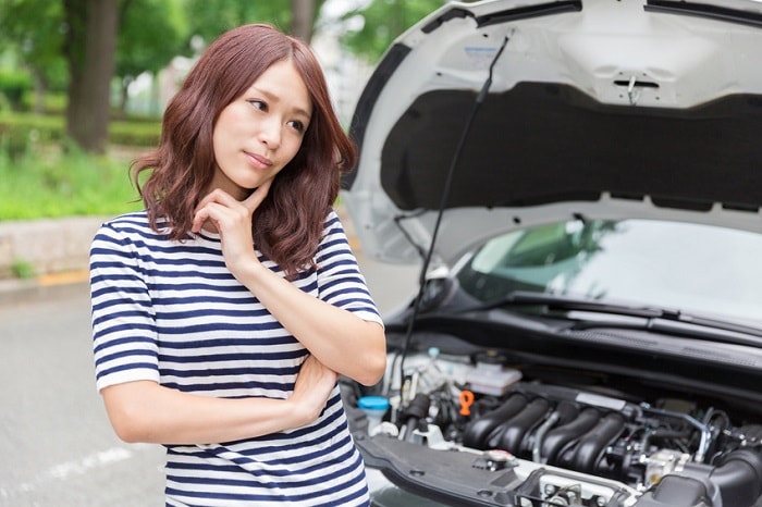 Woman_Standing_By_Broke_Down_Car.jpg