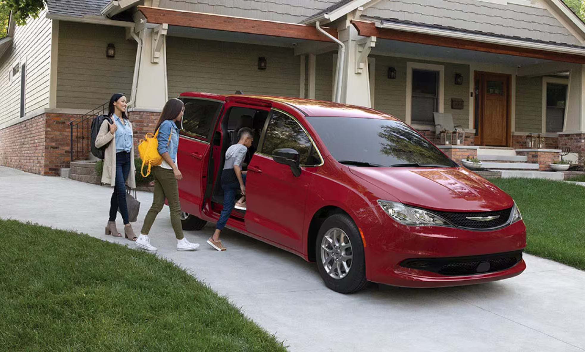 Red 2026 Chrysler Voyager and a family