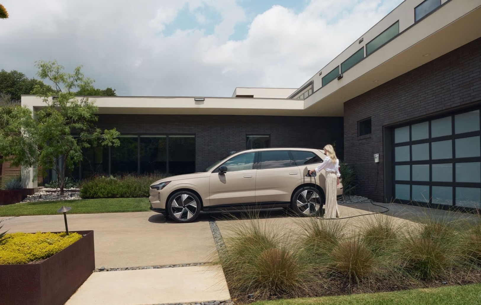 2026 Volvo EX90 plugged in at home with a woman