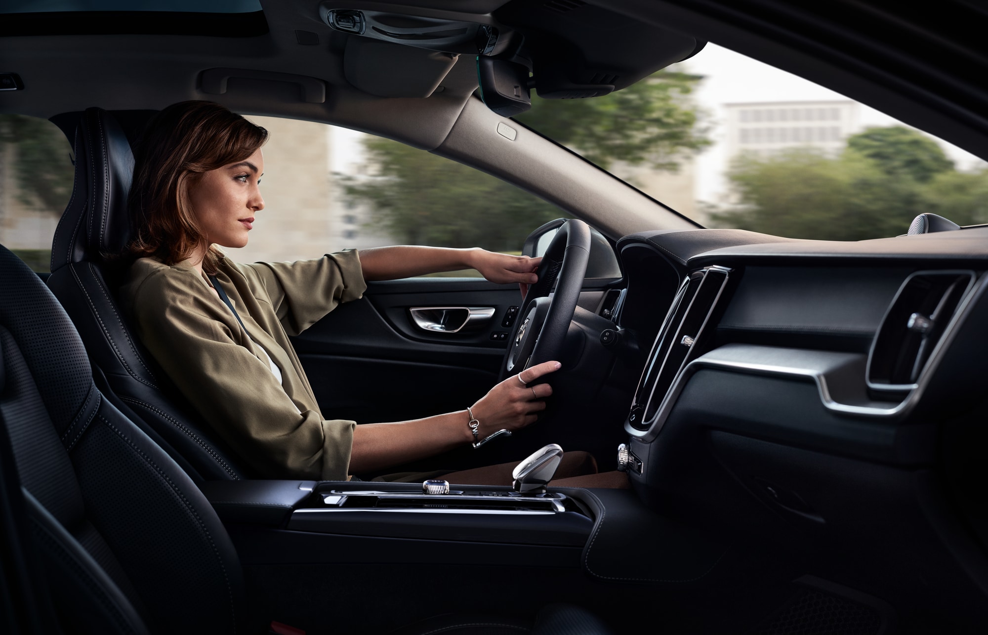 Woman driving a Volvo car and using safety features