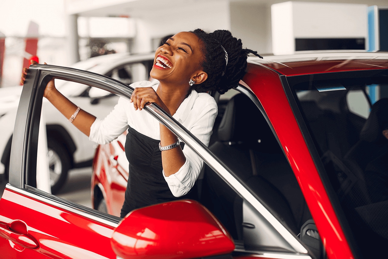 excited woman in a red car