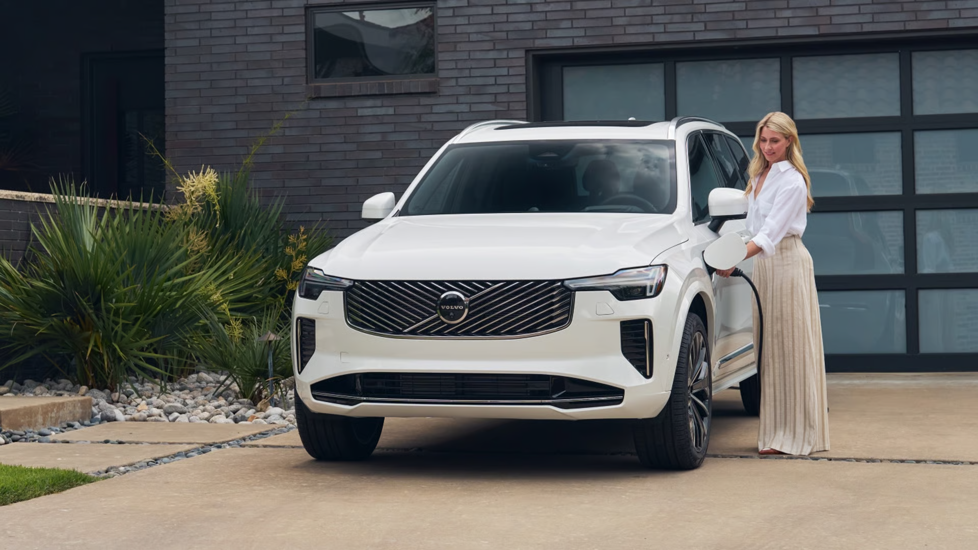 Woman charging a Volvo XC90 PHEV