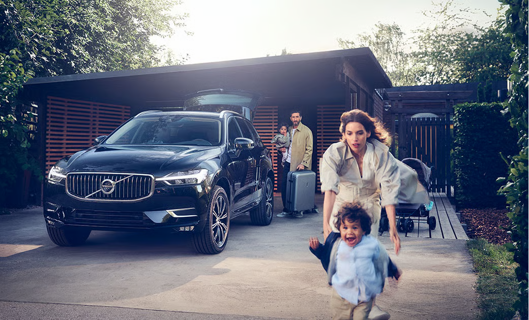 Woman trying to keep a child from running into traffic while family watches on