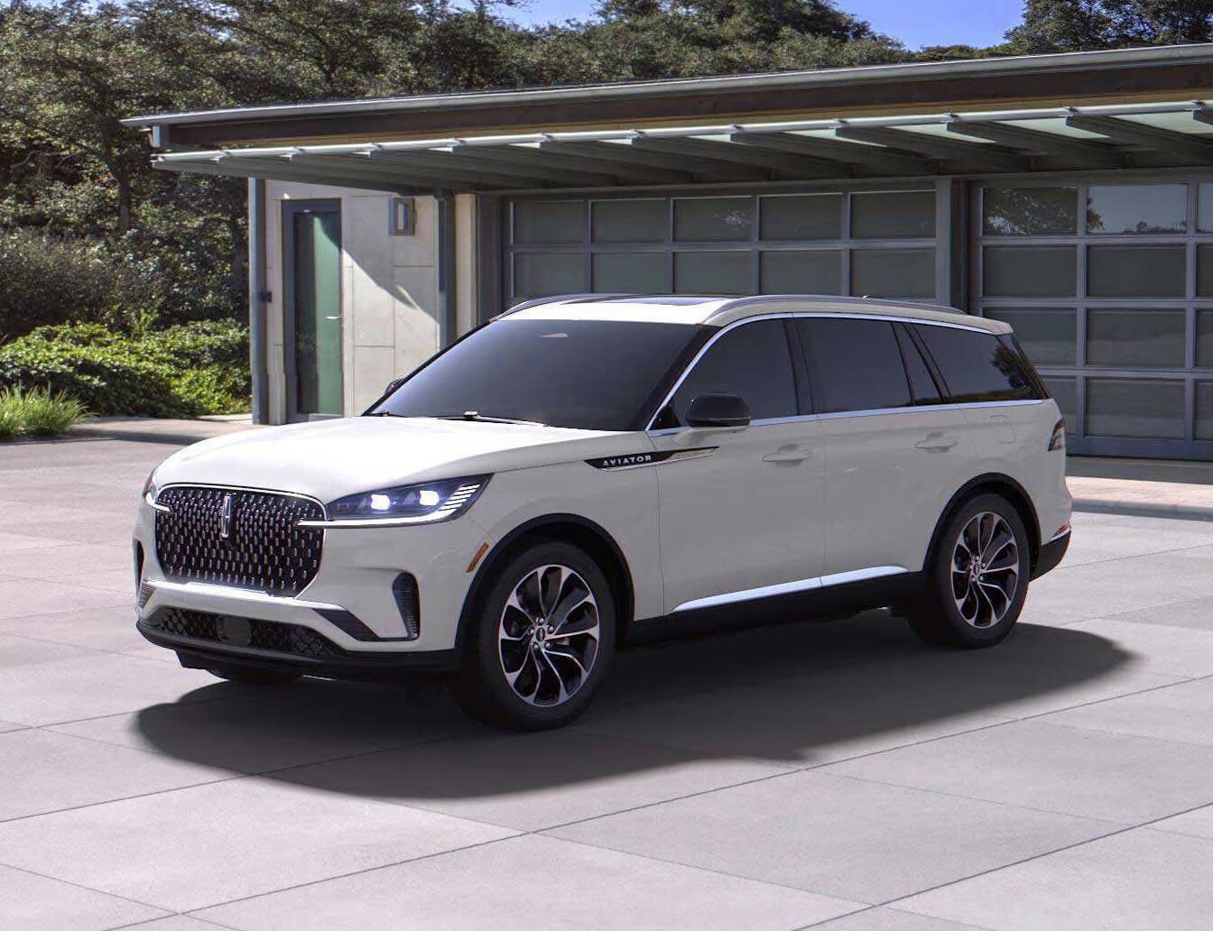 Three-quarter front view of a Lincoln Aviator Reserve in White showcasing its sleek profile on a modern driveway.