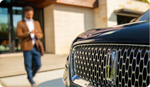 Man walking towards their lincoln vehicle after exiting their home