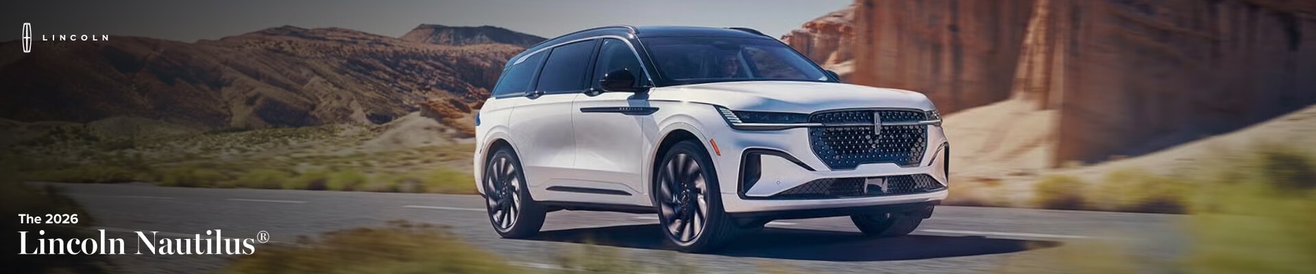 A white 2026 Lincoln Nautilus drives down a remote desert highway.