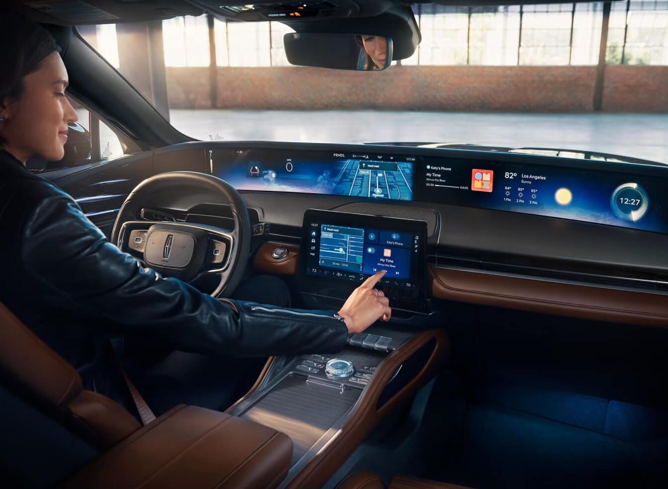 Perspective interior shot of the 2026 Nautilus cockpit. A driver touches the infotainment screen.