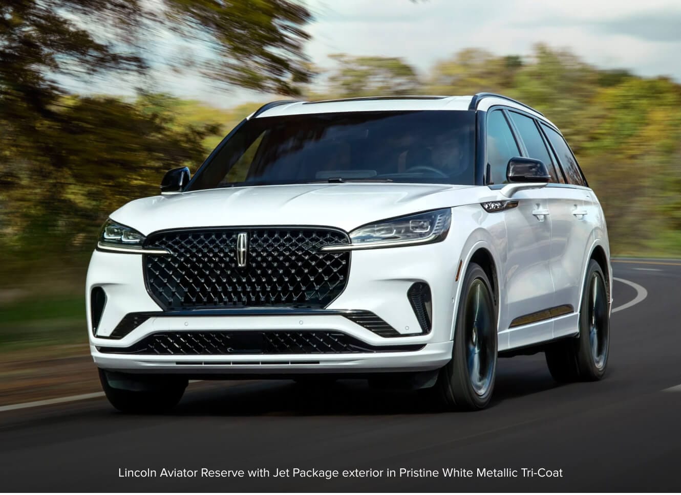 Lincoln Aviator Reserve speeds along a curving asphalt highway.