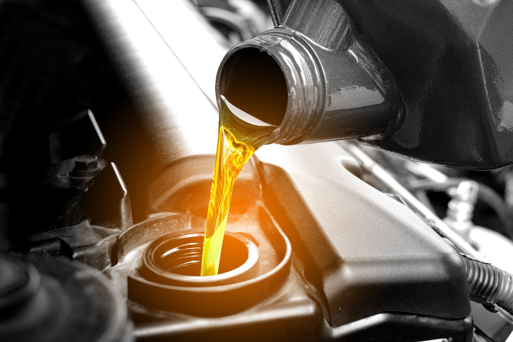 New, clean oil being poured into the vehicle's oil reseviour. The service member is performing an oil change.