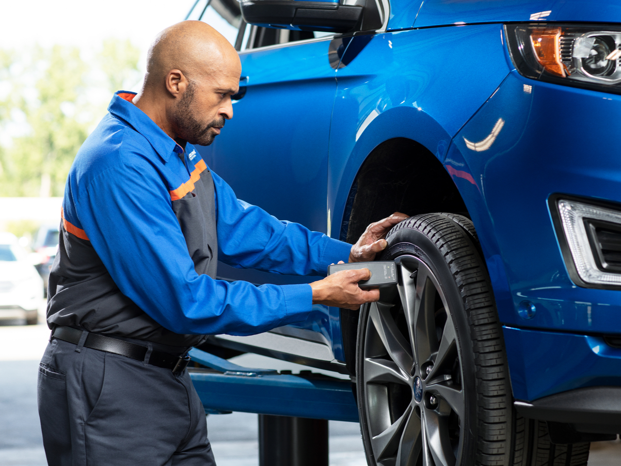 Ford Service Ford service staff adjusting a wheel from a Ford vehicle