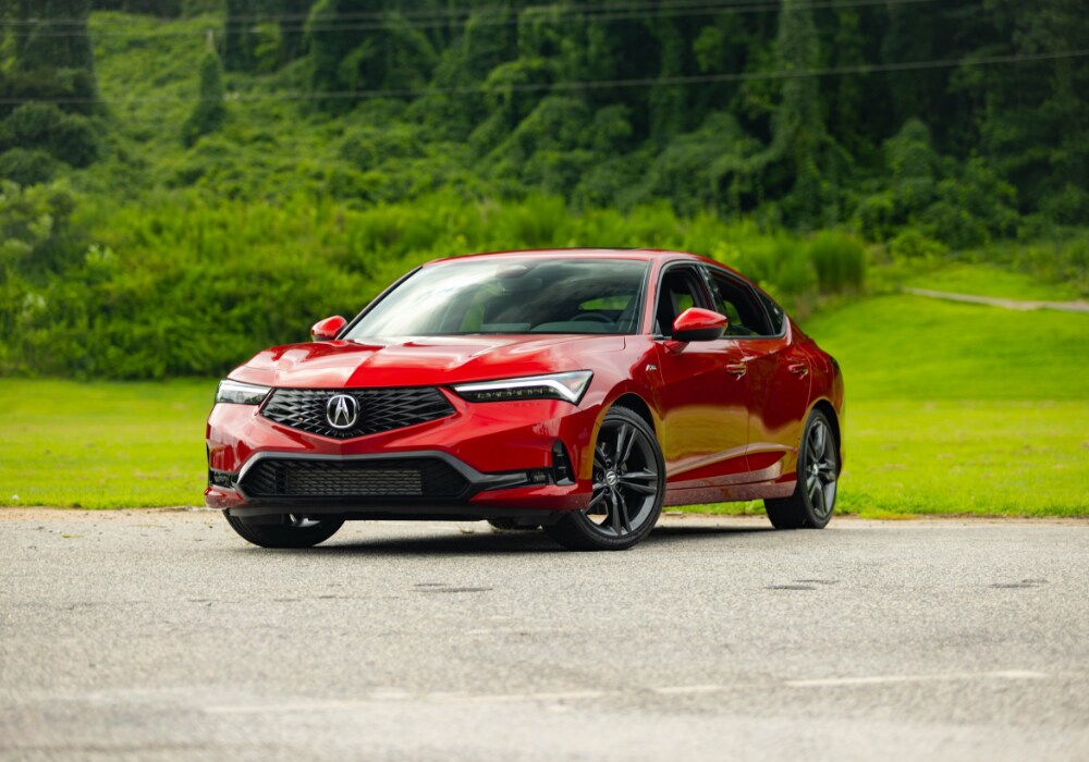 2025 Acura Integra parked in a parking lot. The Integra is bright red.
