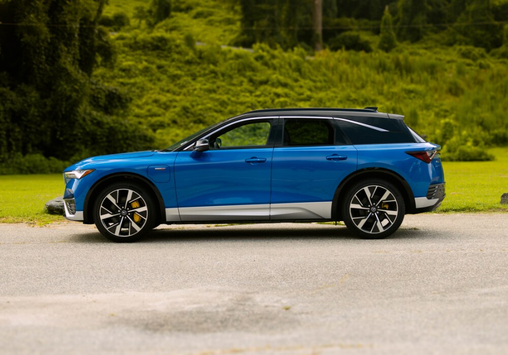 Driver's side exterior view of a new Acura ZDX parked in front of trees
