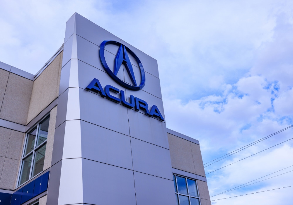 Acura logo outside the Flow Acura dealership storefront in Winston-Salem, NC