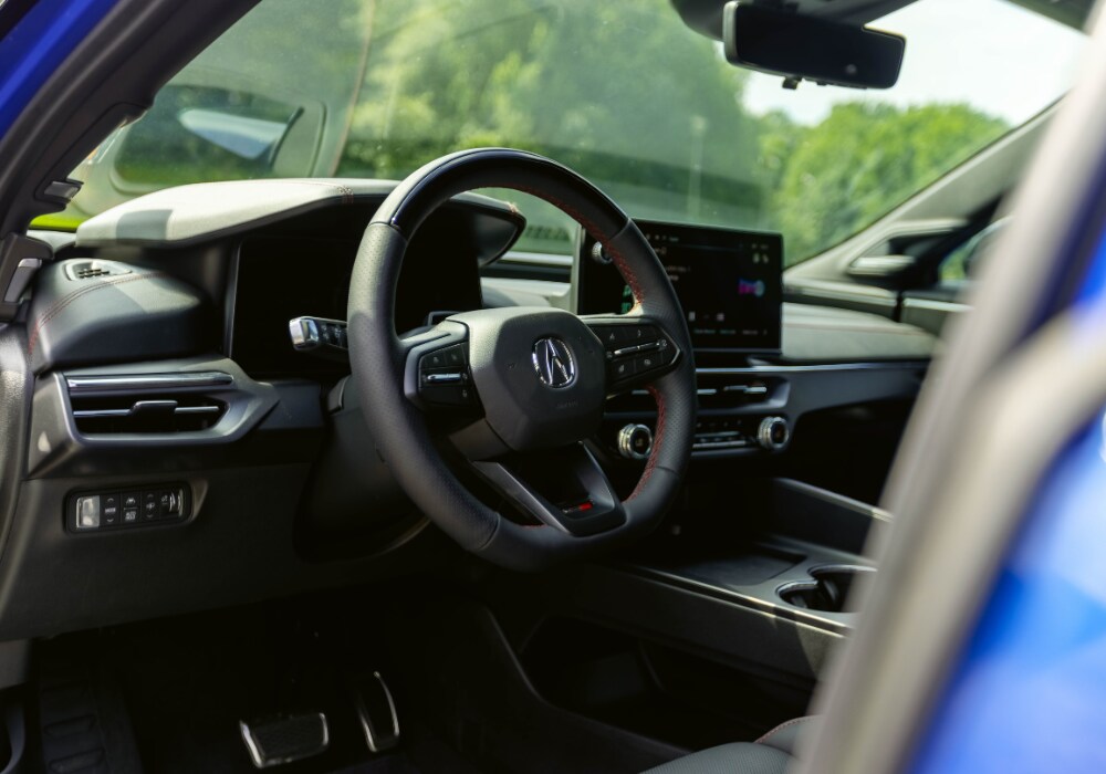 2025 Acura ZDX interior showing the steering wheel and front dash. The interior is black