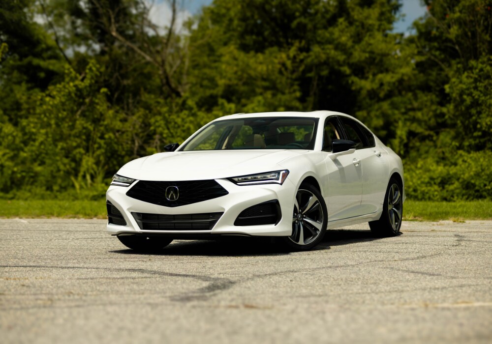 image of a white 2025 Acura Integra in a parking lot with grass and trees in the background