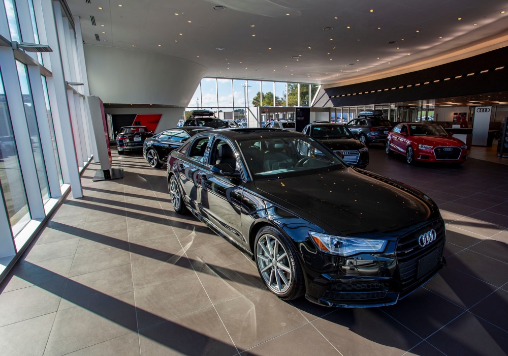Several Audi cars and SUVs parked inside the showroom at the Audi Winston-Salem dealership