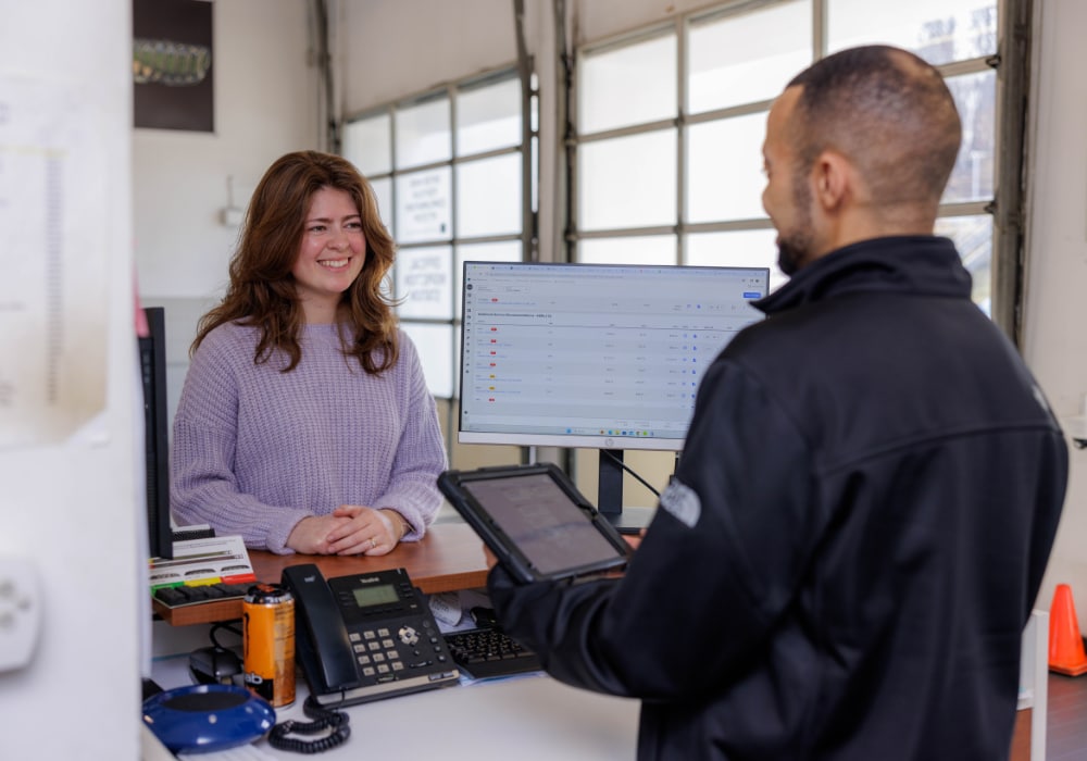 A Flow service employee helps a customer from behind a service desk