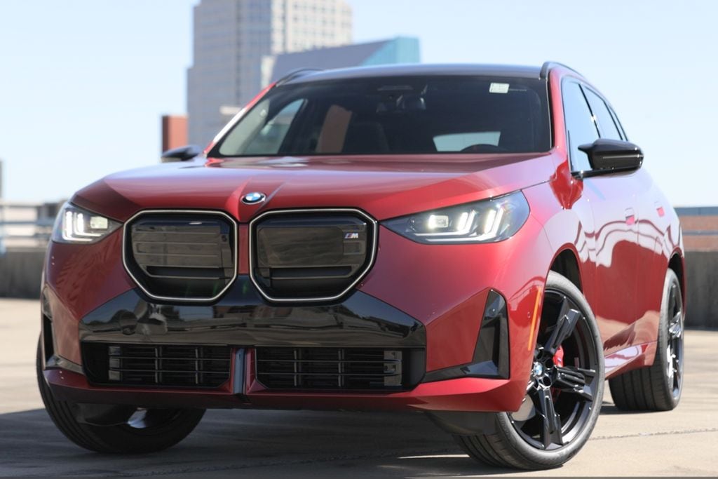 bmw-x3-lease-specials.jpg Close up shot of the front of a red 2025 BMW X3. the headlights are on and the BMW logo is visible above the grille