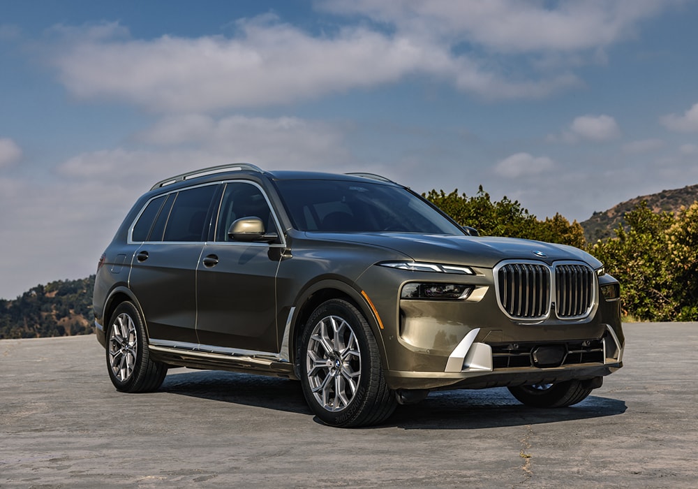 bmw-x7-for-sale-winston-salem.png Gray 2025 BMW X7 for sale. The SUV is parked on a paved surface with a blue sky in the background