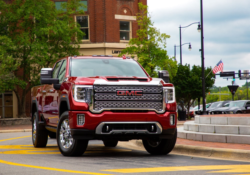 Red GMC Sierra 1500 truck driving through downtown Fayetteville, NC