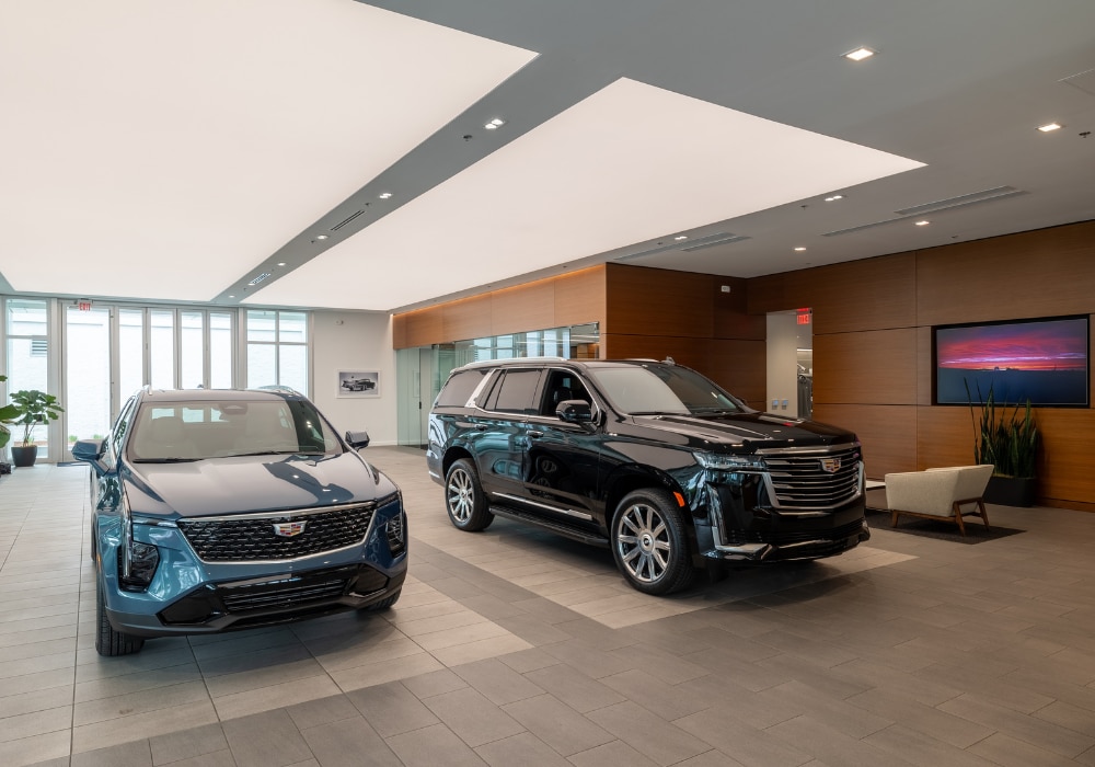 Two Cadillac cars parked inside the showroom of Flow Cadillac of Wilmington