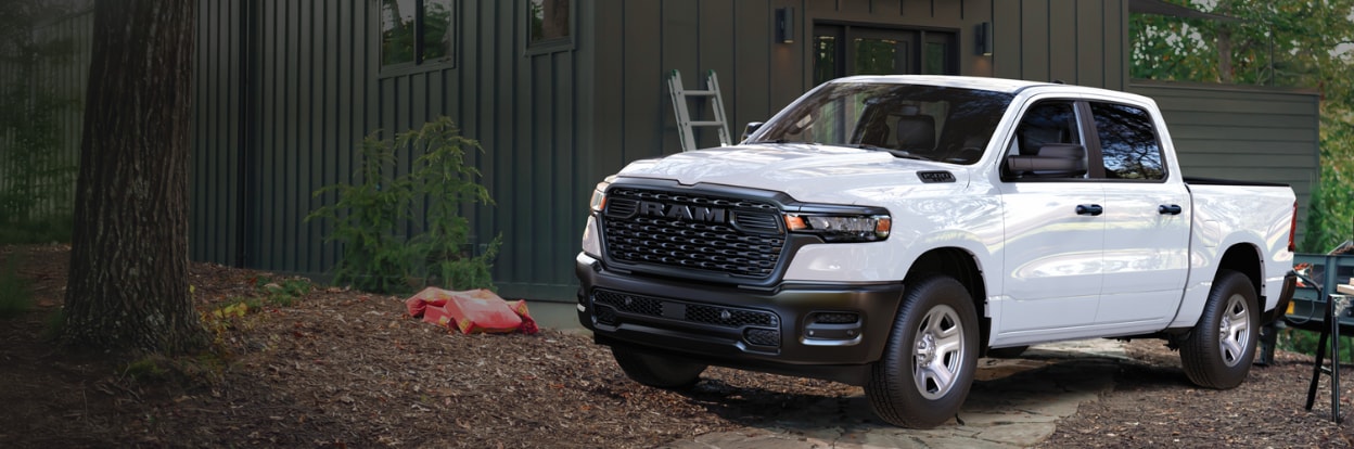 White RAM pickup truck parked in front of a shed