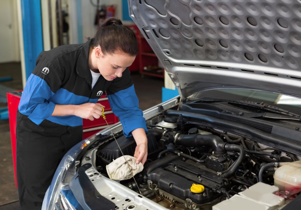 manufacturer certified technician checking the oil levels in a car